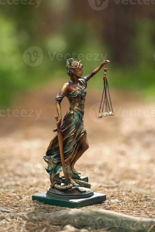 estatua de themis contra un fondo de naturaleza. símbolo de justicia y ley, crimen y castigo. foto
