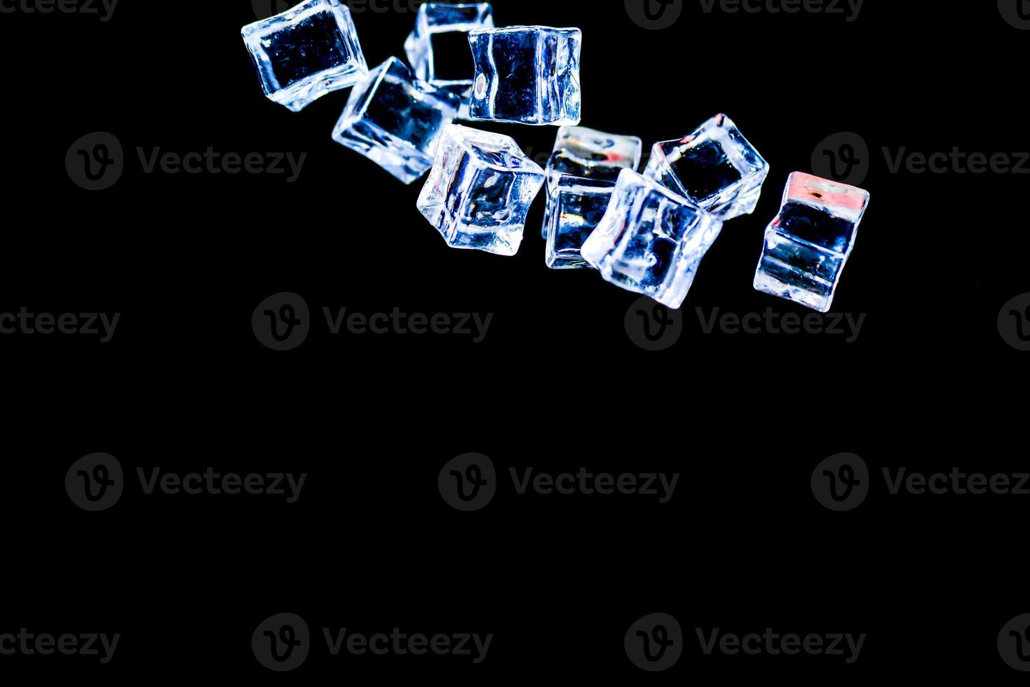 Ice cubes on a black background. ice falling on a black background for use as an illustration in a project photo