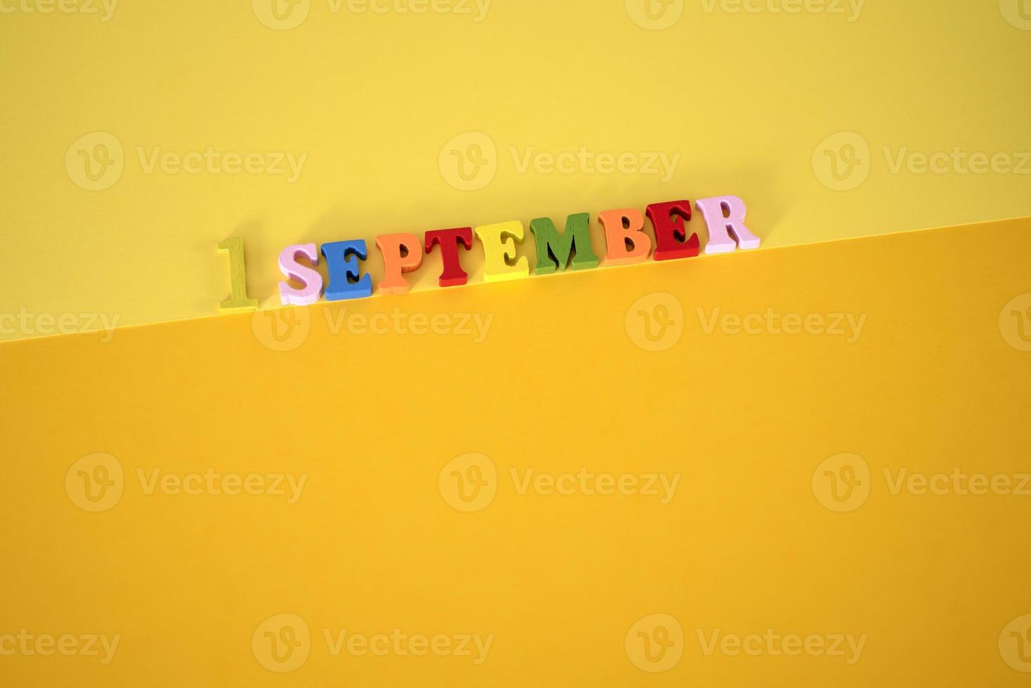 September 1 on a wooden calendar on a yellow background. photo