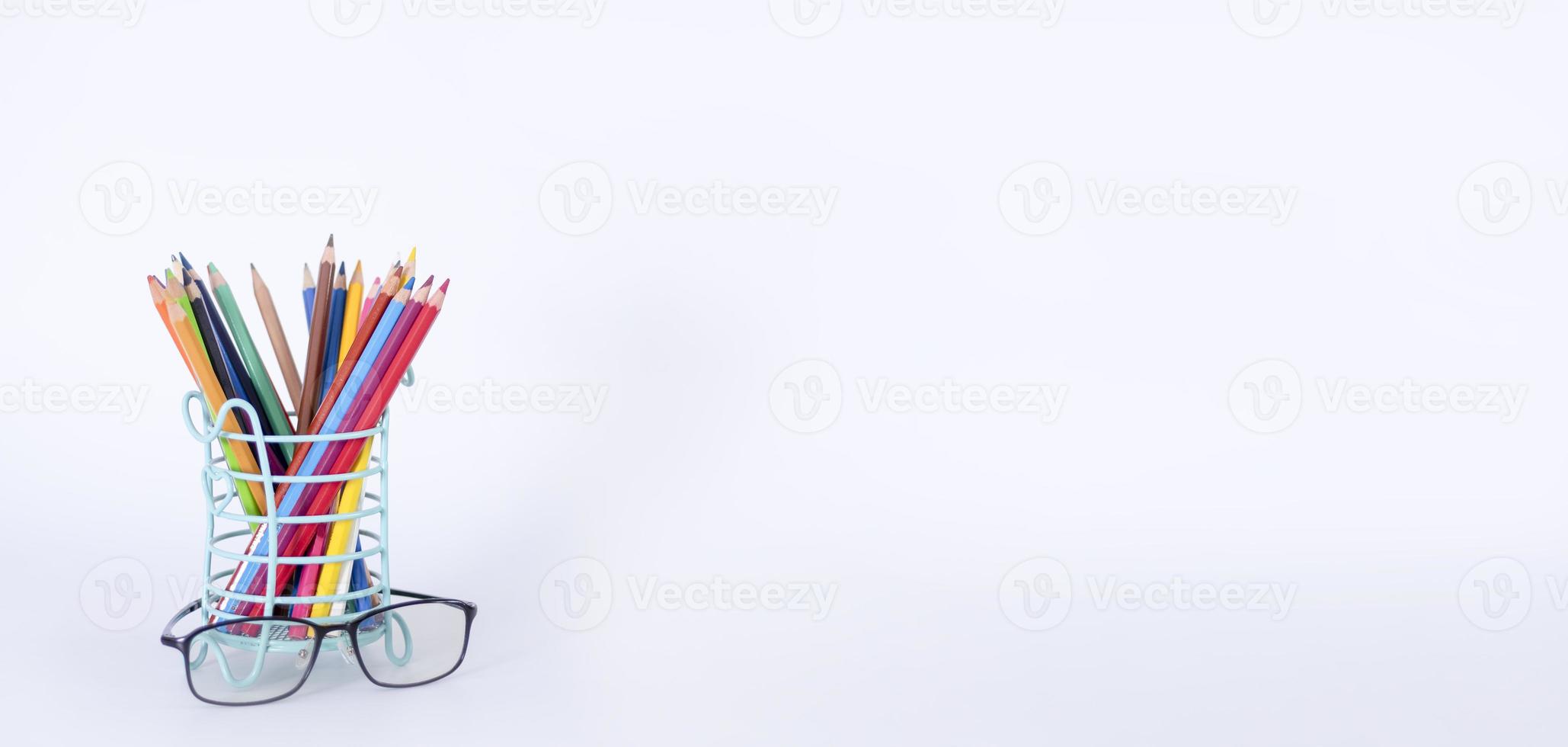 A stack of books, study guides, textbooks, glasses, and pencils in a text copy holder. photo