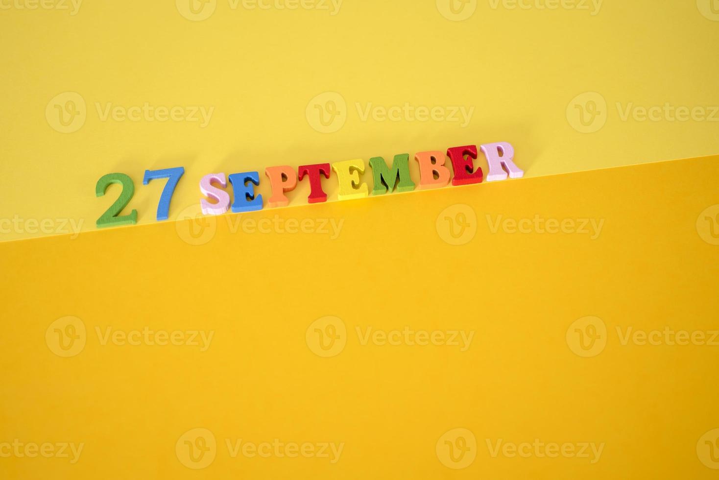 September 23 on a yellow and paper background with wooden letters and numbers in different colors. photo