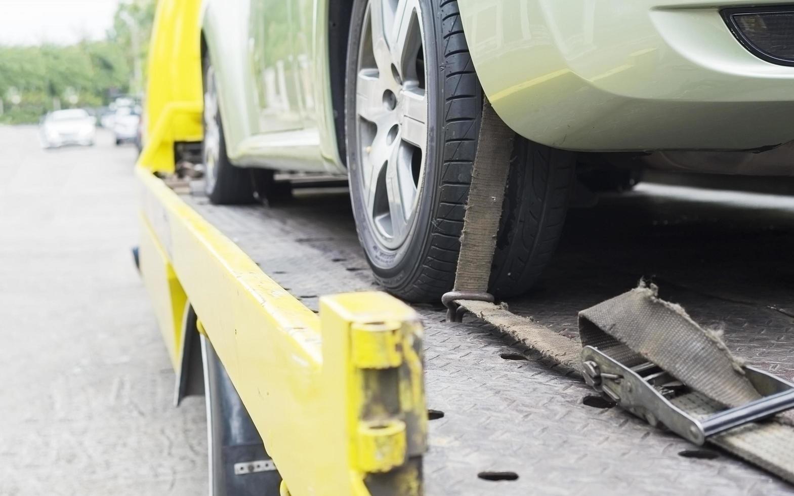 car transporter breakdown lorry during working using locked belt transport other green car for repairing at car center in a bangkok city thailand photo