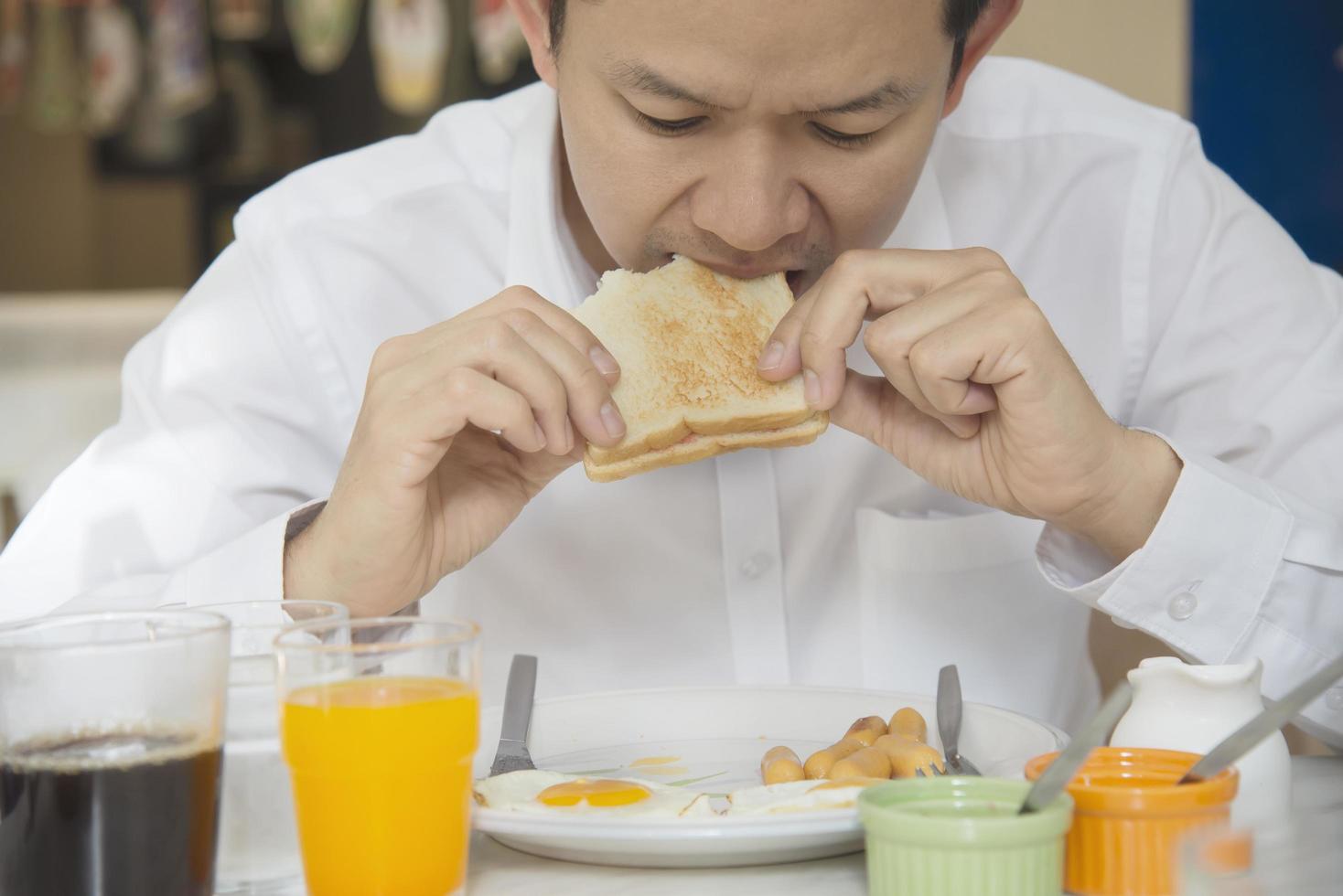 Business man eat the American breakfast set in a hotel - people take a breakfast in hotel concept photo