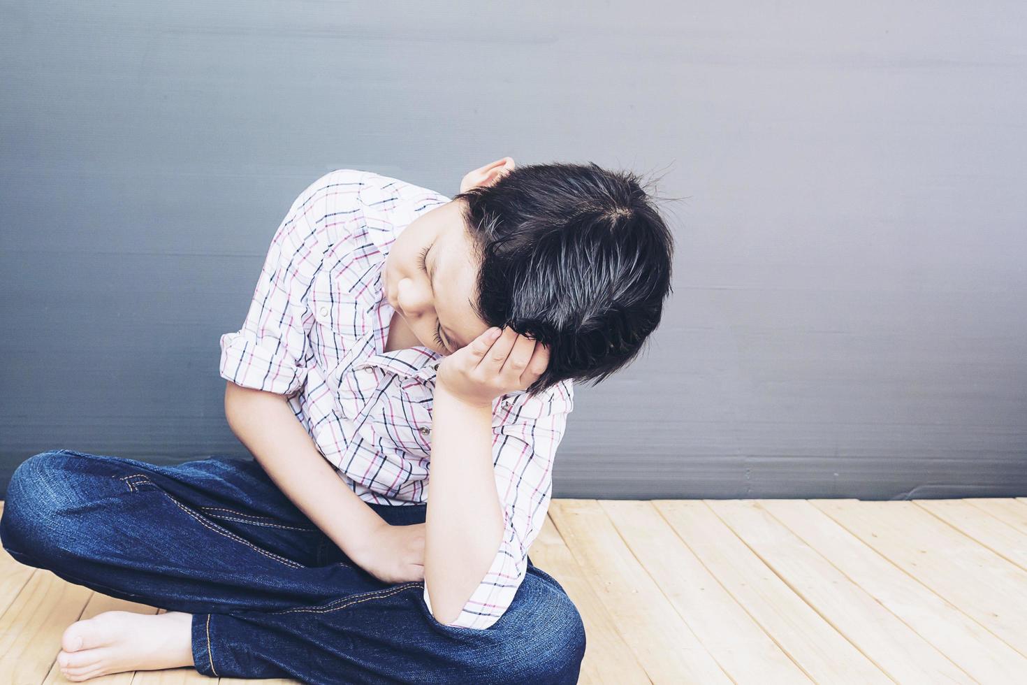 7 years old Asian boy is feeling sad photo