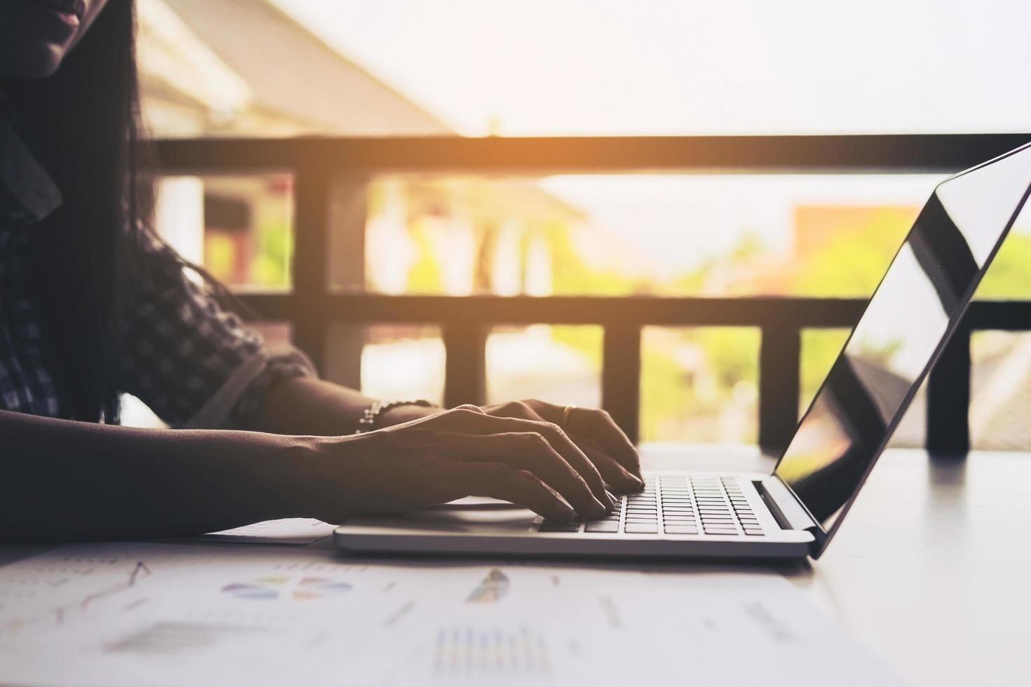 Business woman is working with laptop computer and chart or graph on a table photo