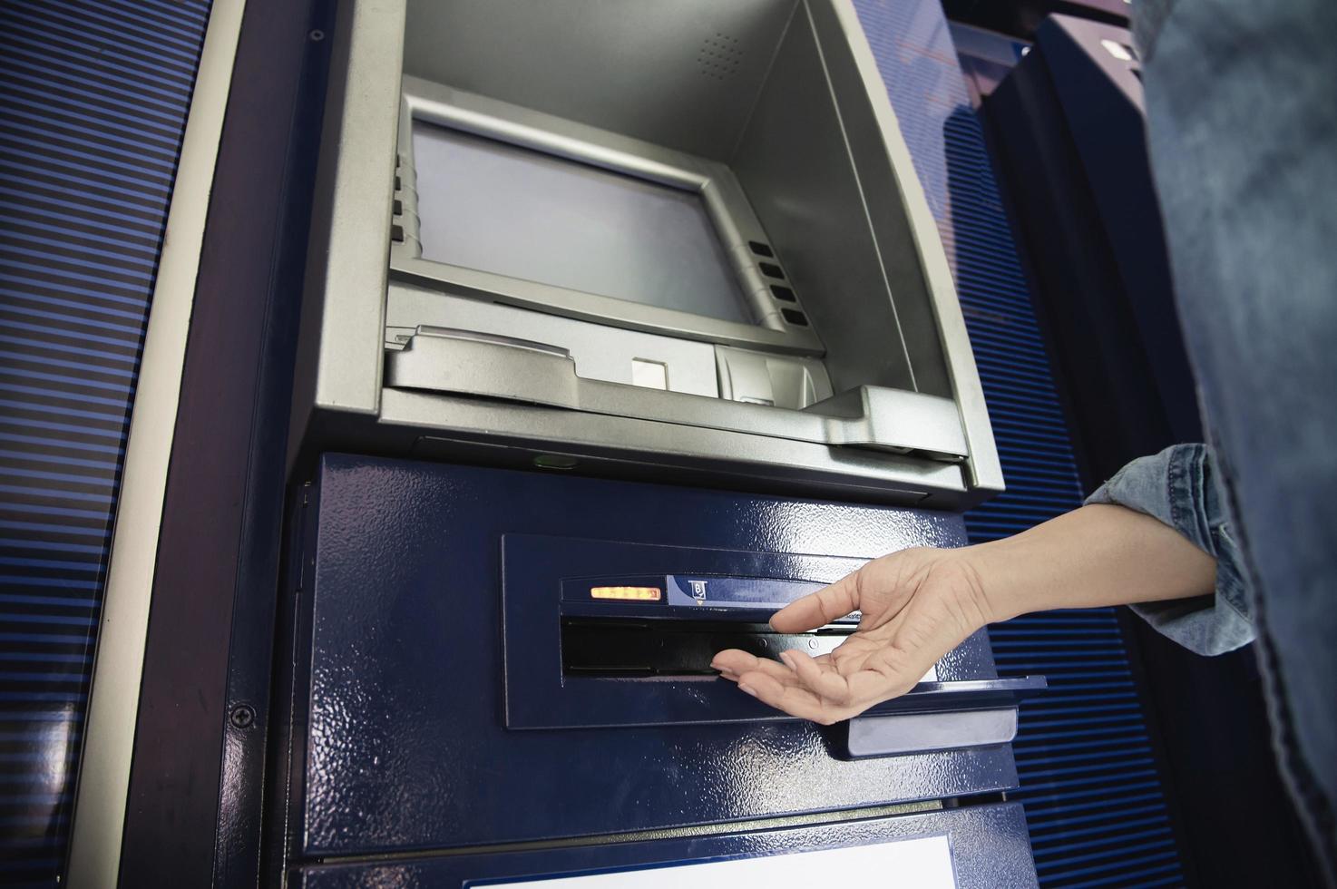 People waiting to get money from automated teller machine - people withdrawn money from ATM concept photo