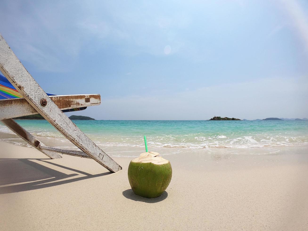 Relax beach chair with fresh coconut on clean sand beach with blue sea and clear sky - sea nature background relax concept photo