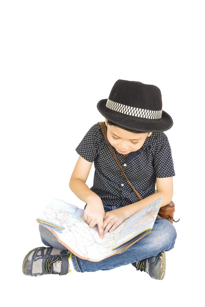 7 years old Asian traveler boy is happily sitting and looking at a map photo