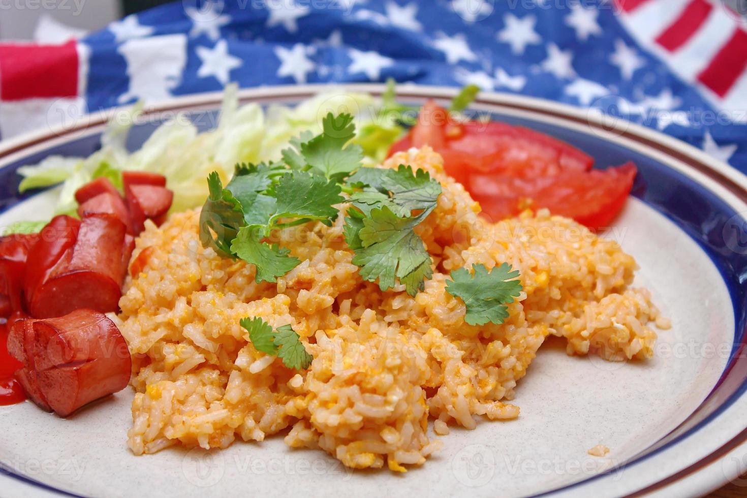 arroz frito con salchicha frita servido en un plato cremoso con tomates y pepinos. foto