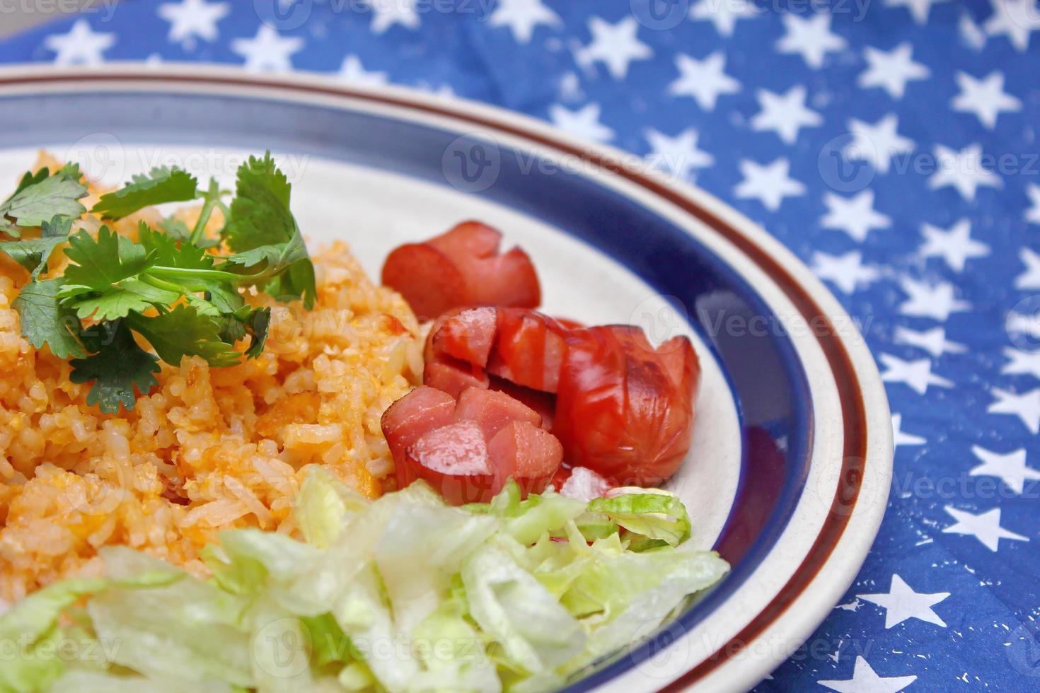 Fried rice with fried sausage served in a creamy dish with tomatoes and cucumbers. photo