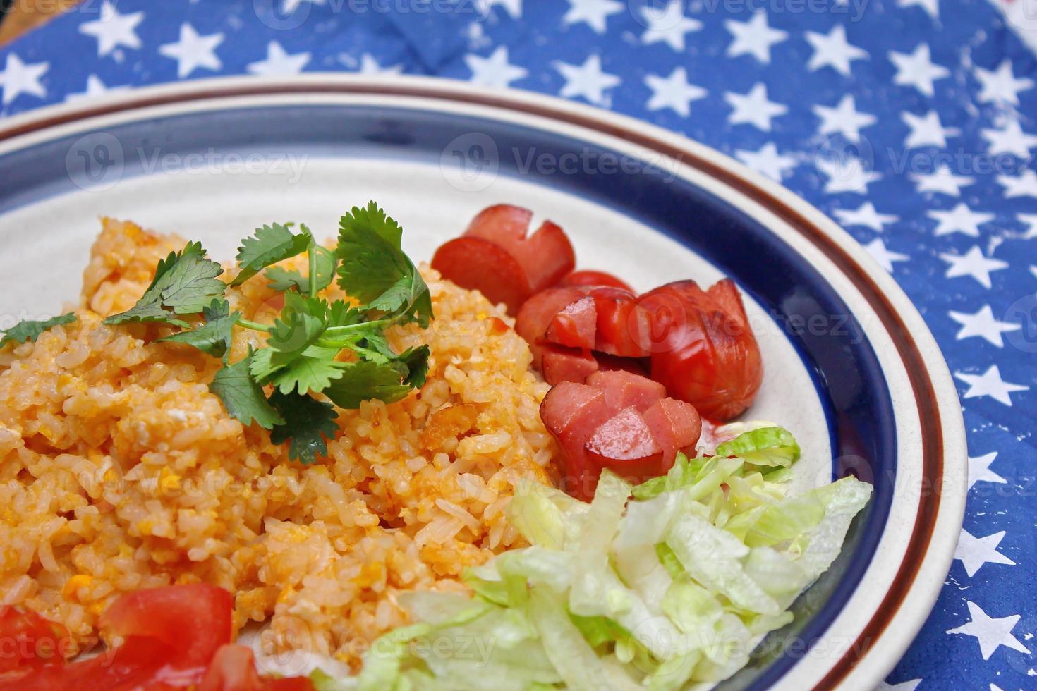 Fried rice with fried sausage served in a creamy dish with tomatoes and cucumbers. photo