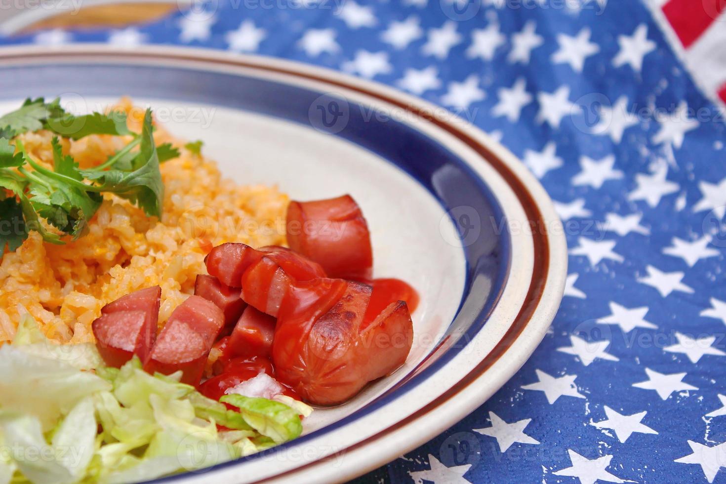 Fried rice with fried sausage served in a creamy dish with tomatoes and cucumbers. photo