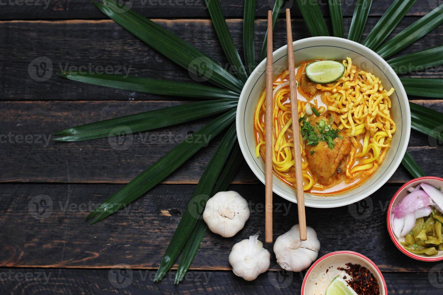 receta de khao soi, khao soi, khao soi kai, fideos tailandeses khao soi, curry de pollo con condimento servido en una mesa de madera foto