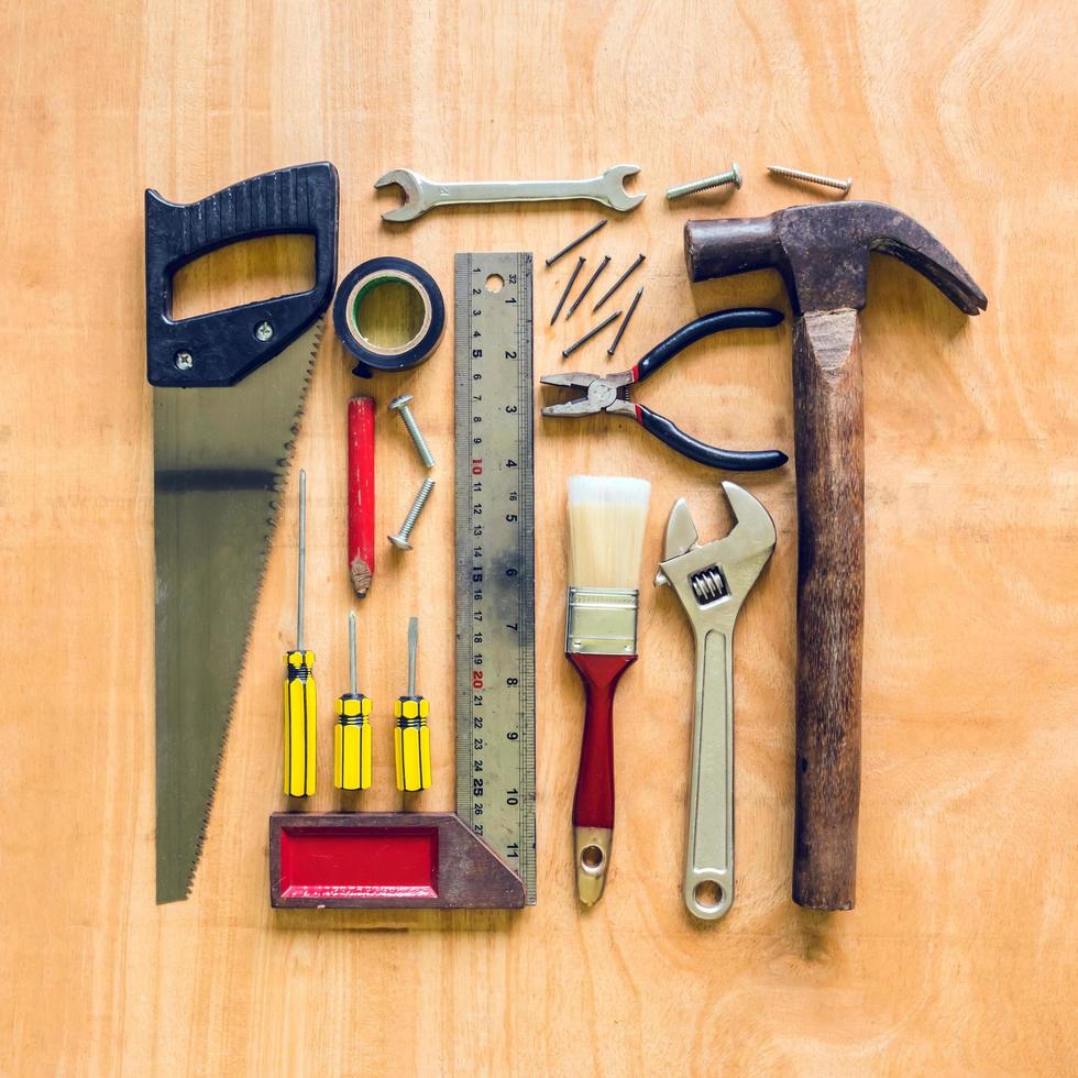 Set of different work tools on wooden table background. photo