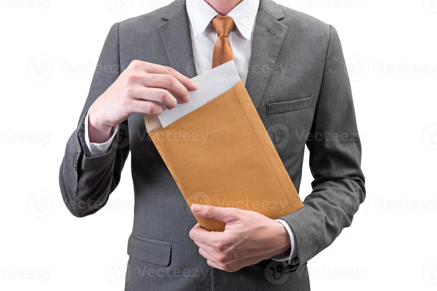 Businessman holding an envelope with blank sheet  isolated on white background. photo