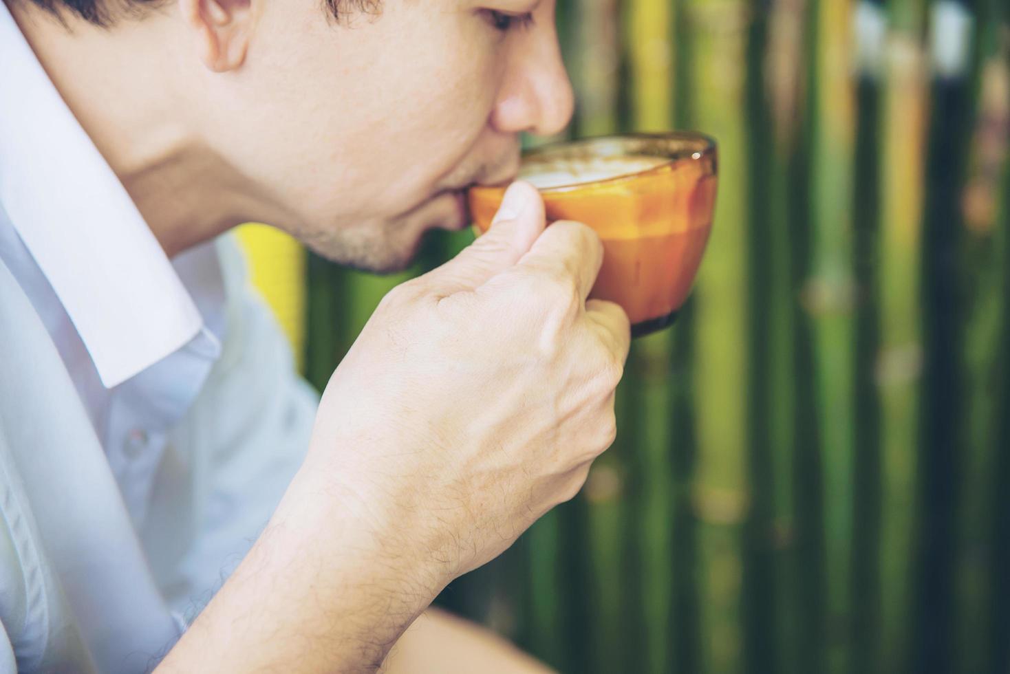 Casual Asian man drink hot coffee happily in nature - people with coffee in nature concept photo