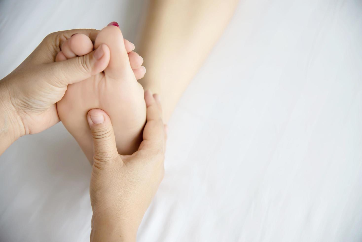 Woman receiving foot massage service from masseuse close up at hand and foot - relax in foot massage therapy service concept photo