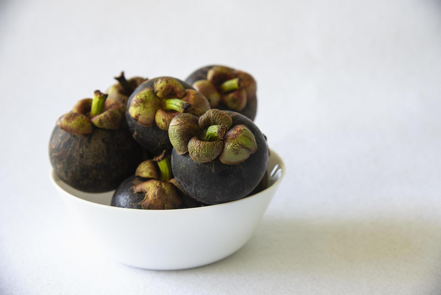 Mangosteen Thai popular fruits - a tropical fruit with sweet juicy white segments of flesh inside a thick reddish-brown rind. photo