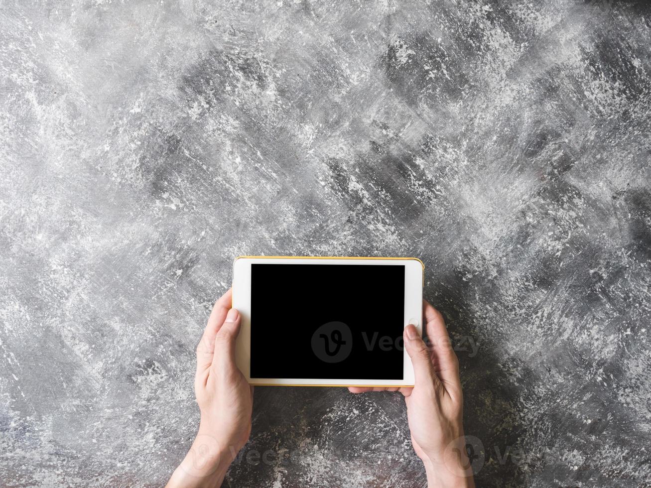 Top view of Male hands using Tablet on grunge gray background. photo