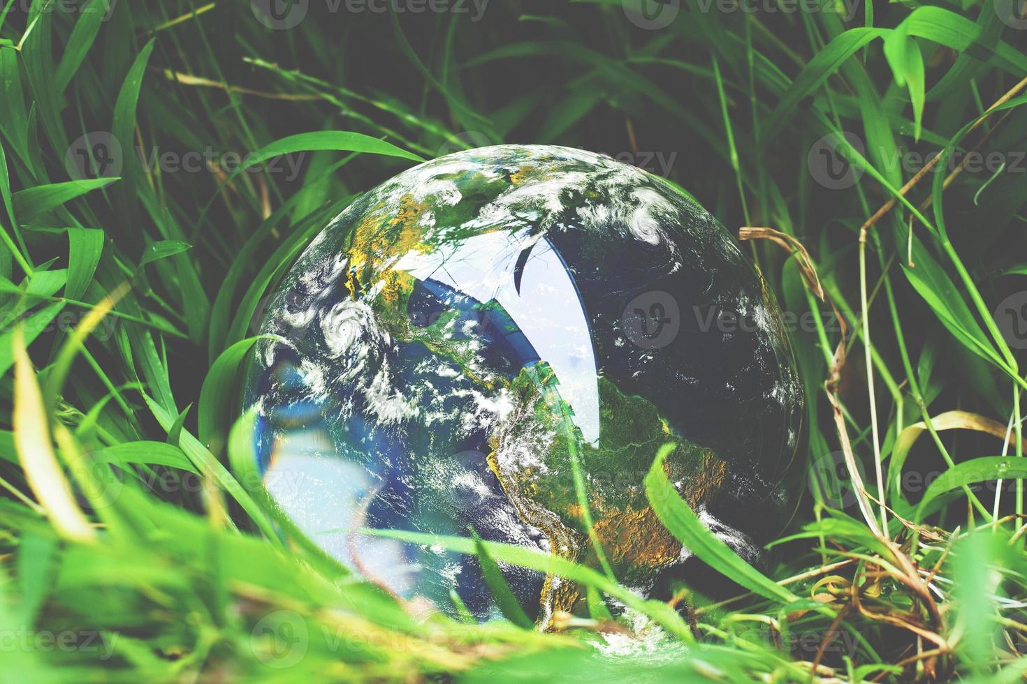 The crystal ball with the world on the grass. concept of the world and nature photo