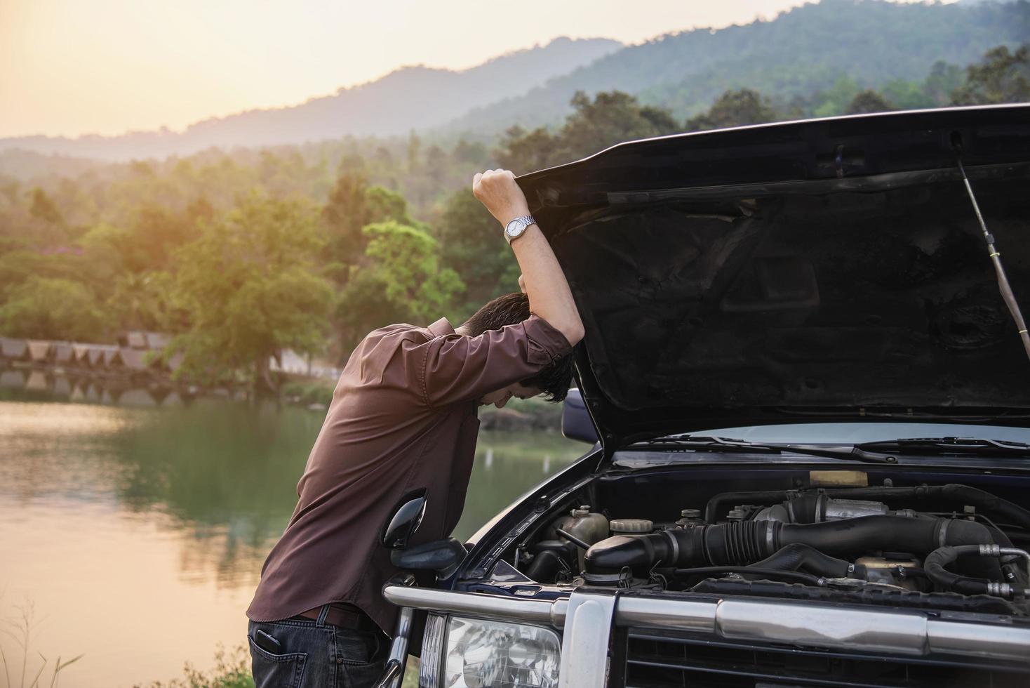 Man try to fix a car engine problem on a local road Chiang mai Thailand - people with car problem transportation concept photo