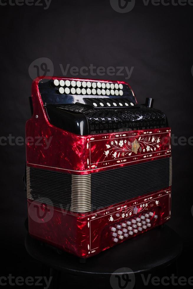 Russian folk instruments.Red bayan on a black background.Russian accordion photo