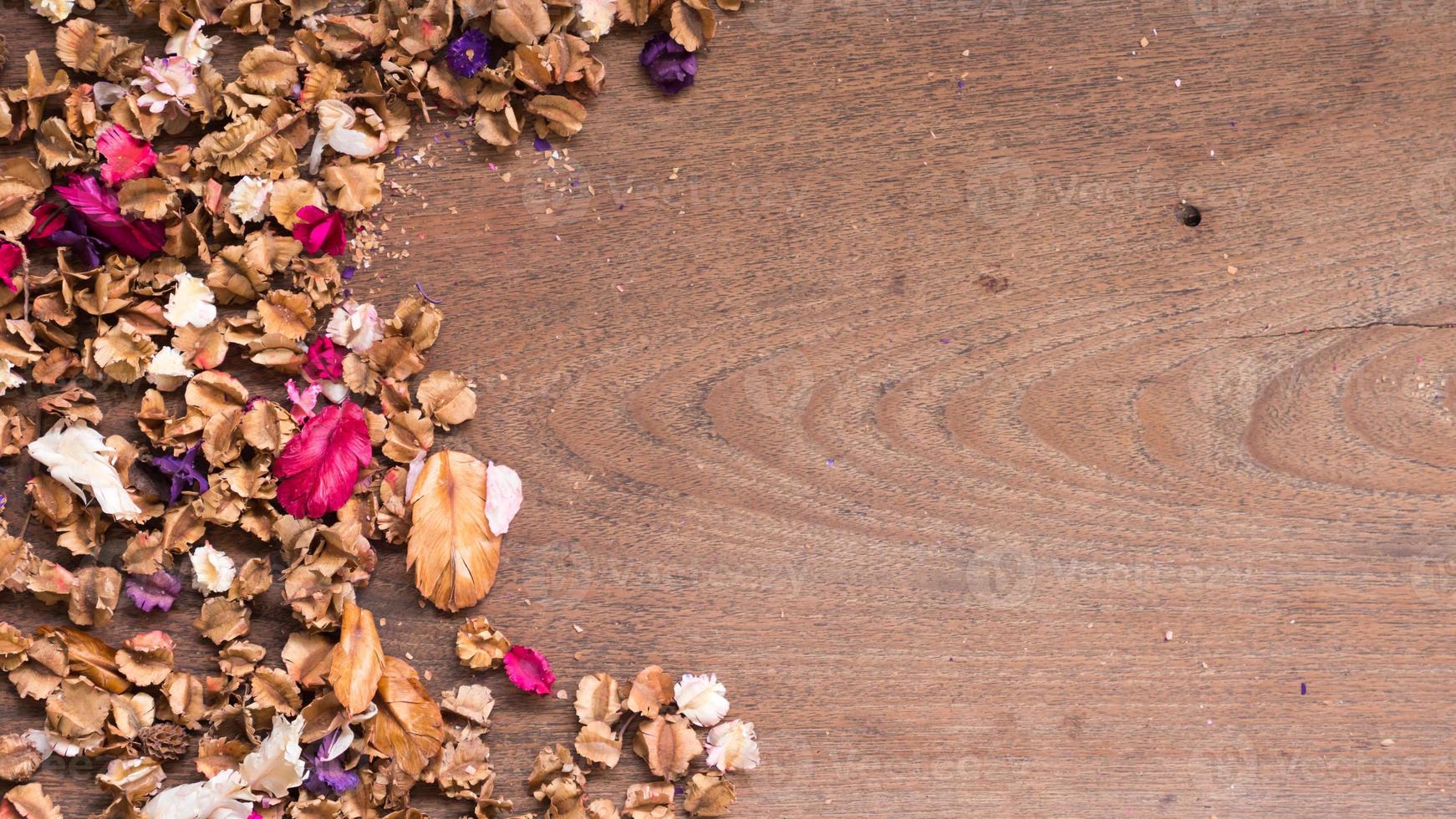 espacio de trabajo de vista superior con flores secas sobre fondo de mesa de madera. espacio libre para su texto. foto