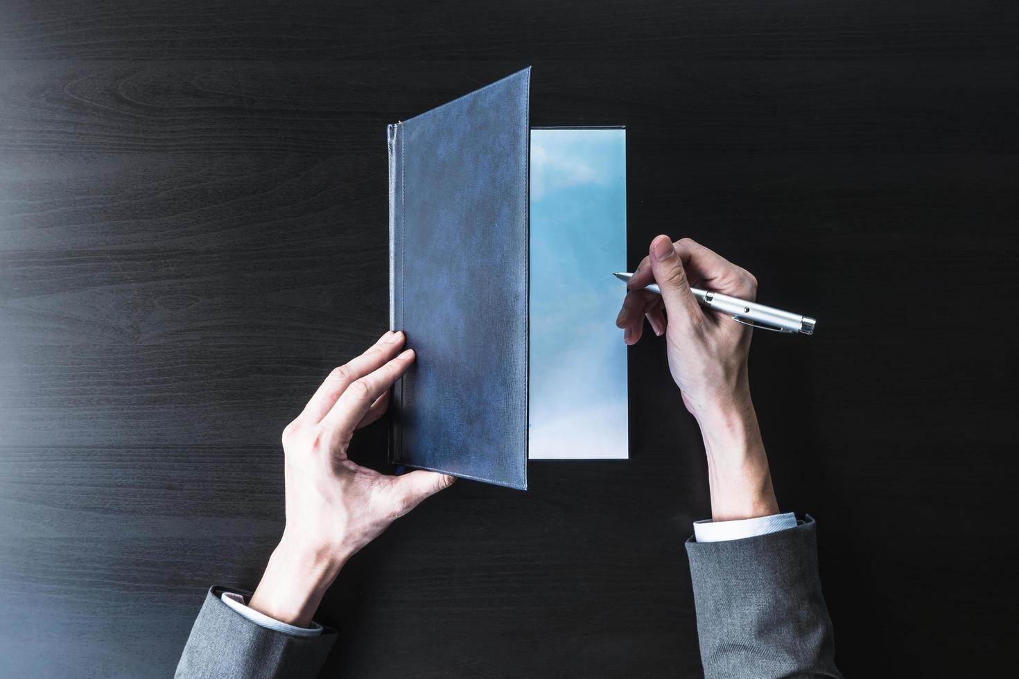Top view of Businessman opening and  checking document on the black desk. photo