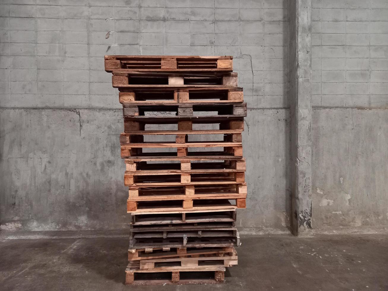 A lot of brown pallets are laid on the cement floor. photo