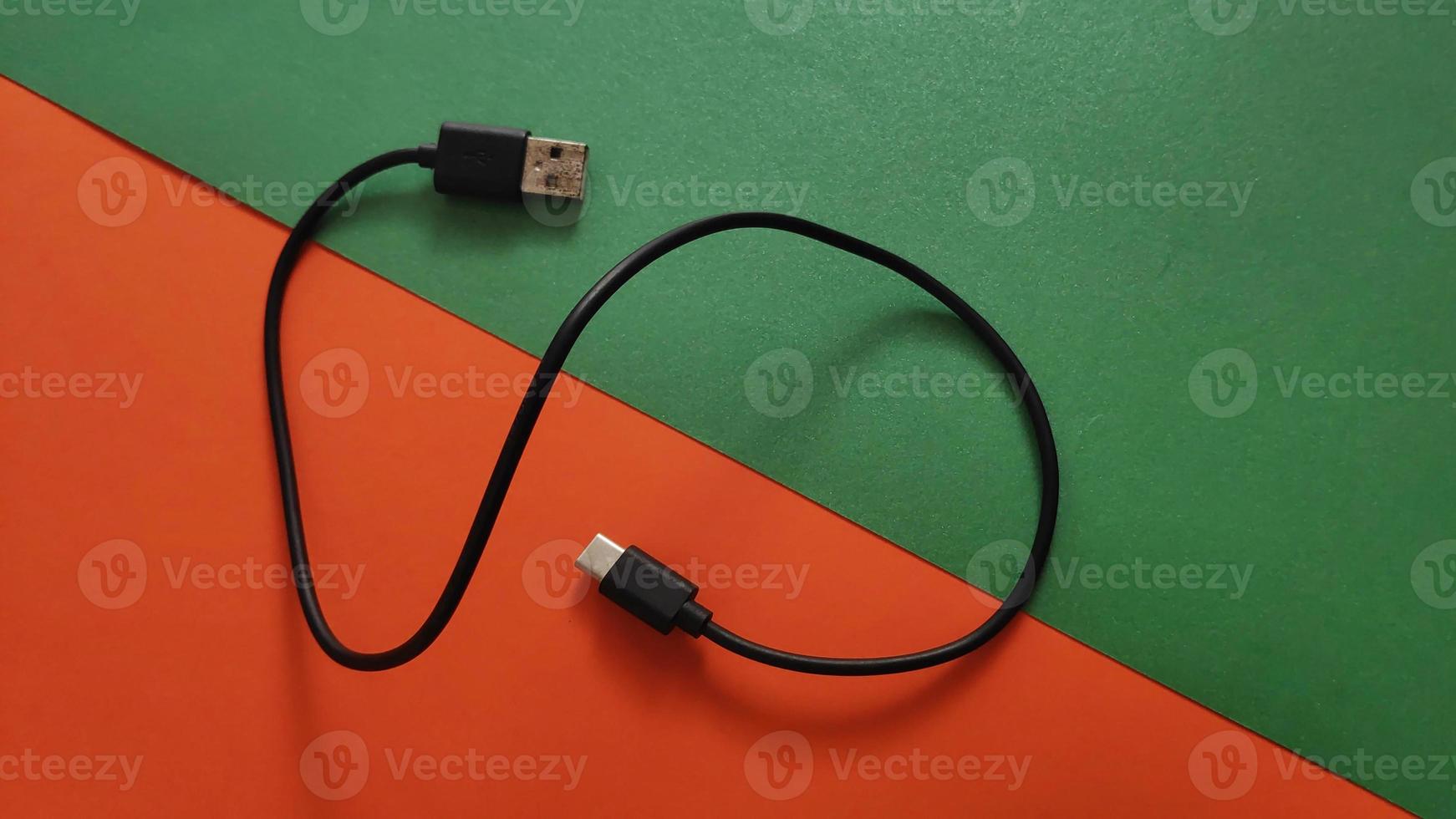 white voltage charger with usb cable for phone and gadgets charge on colored and lighting background photo