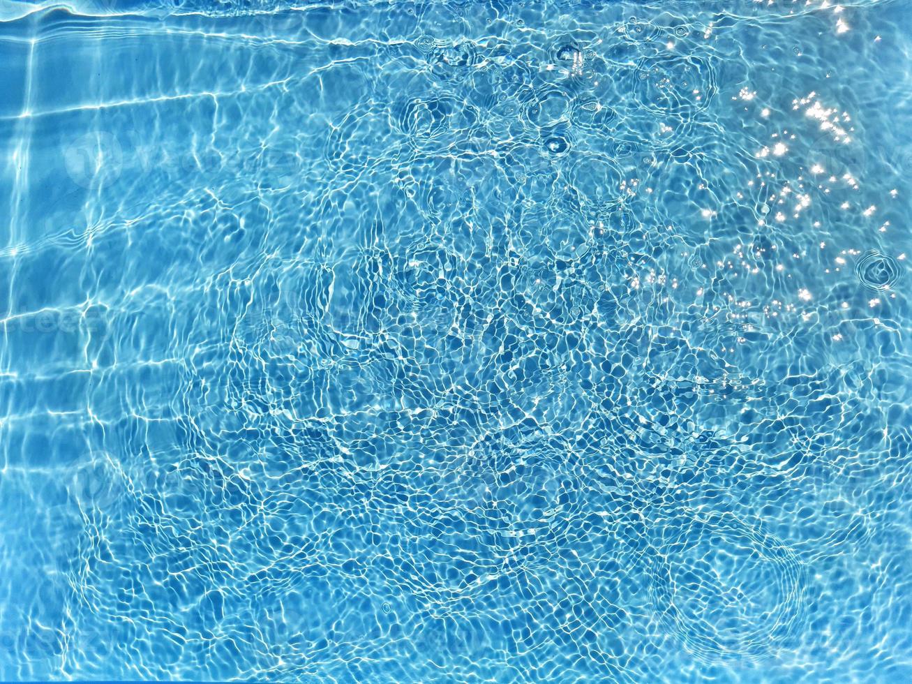 Defocus blurred blue water shining in the sea. rippled water detail background. The water surface in the sea, ocean background. Water wave under sea texture background. photo