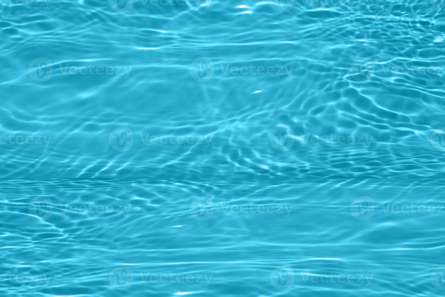 Defocus blurred blue water shining in the swimming pool. rippled water detail background. The water surface in the sea, ocean background. Water wave under sea texture background. photo