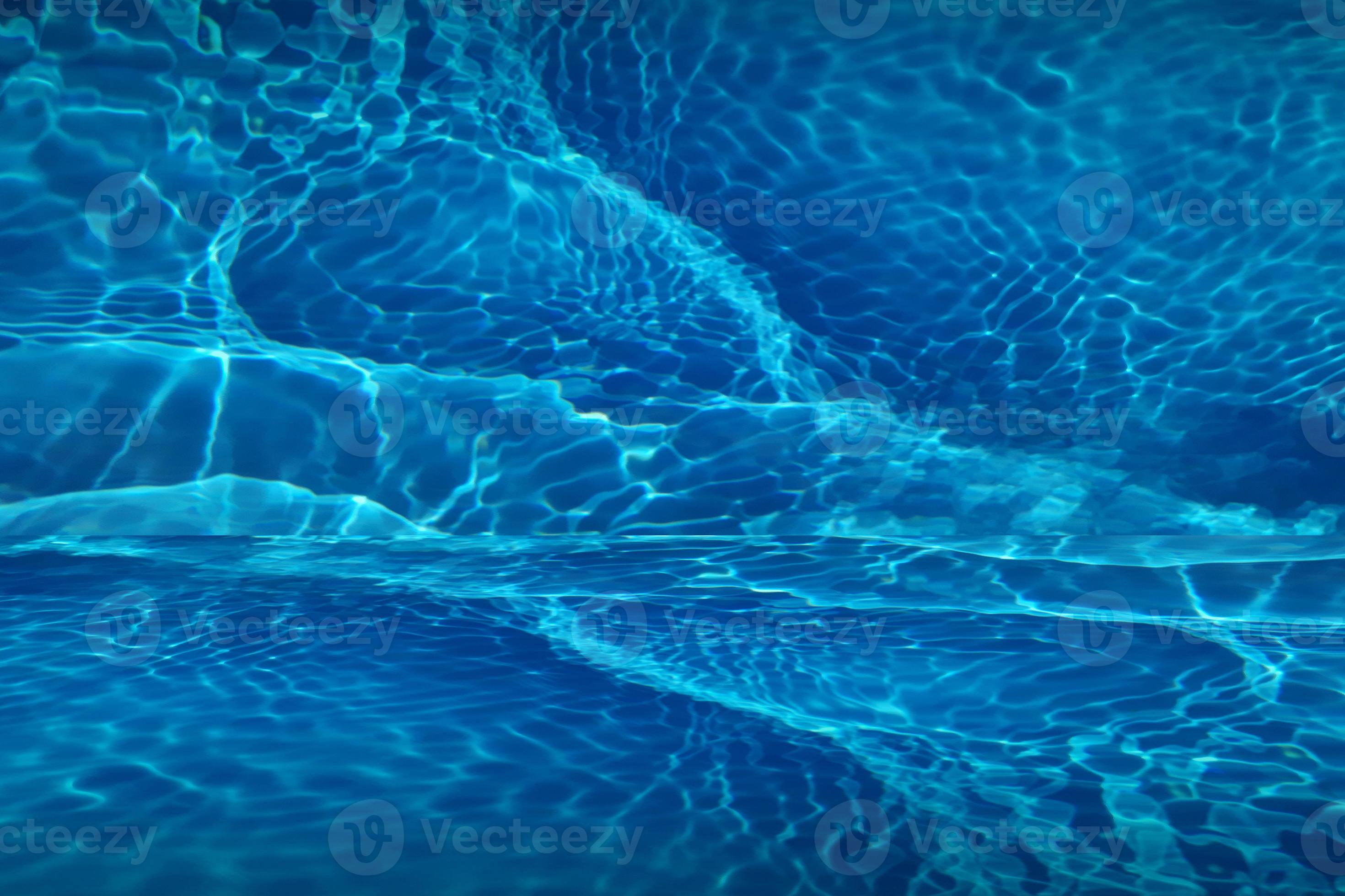 Defocus blurred blue water shining in the swimming pool. rippled ...