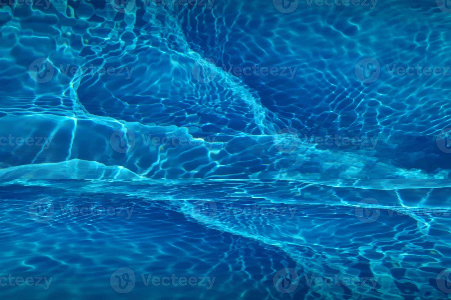 Defocus blurred blue water shining in the swimming pool. rippled water detail background. The water surface in the sea, ocean background. Water wave under sea texture background. photo