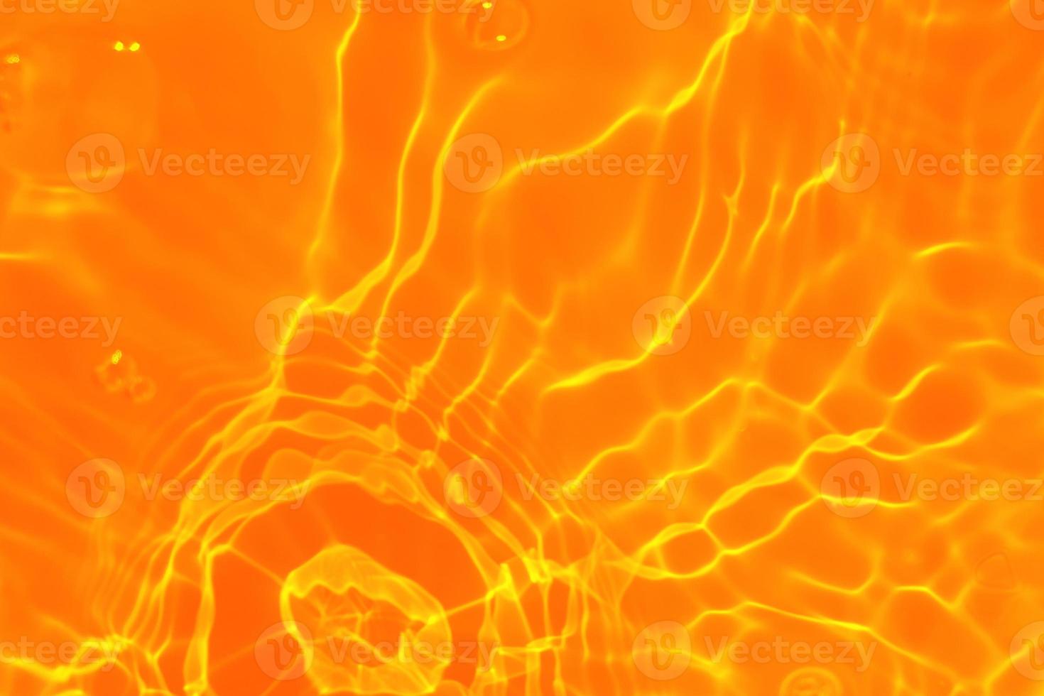 Defocus blurred transparent orange colored clear calm water surface texture with splashes and bubble. Trendy abstract nature background. Water wave in sunlight with copy space. Blue watercolor texture photo