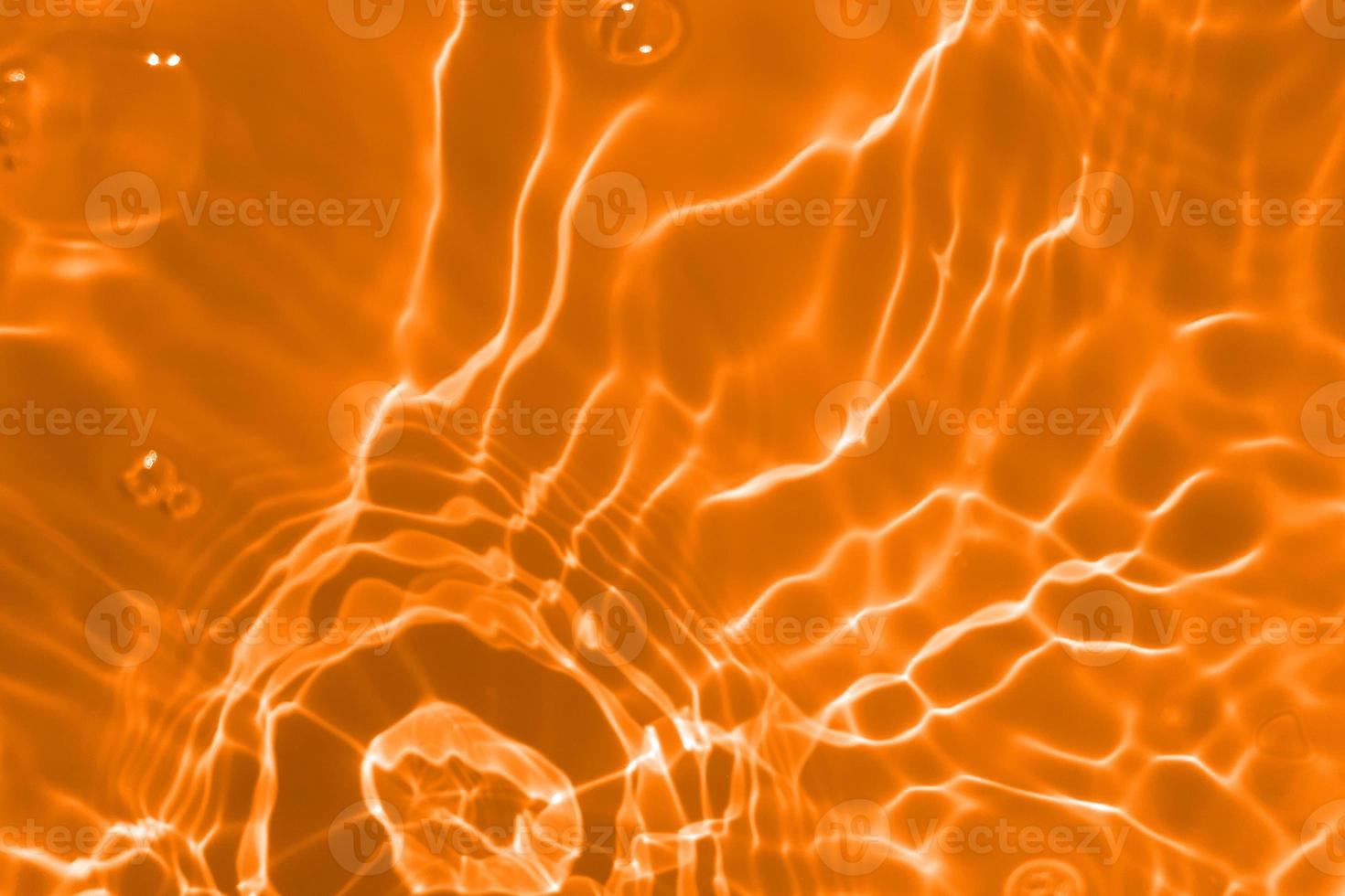 Defocus blurred transparent orange colored clear calm water surface texture with splashes and bubble. Trendy abstract nature background. Water wave in sunlight with copy space. Blue watercolor texture photo
