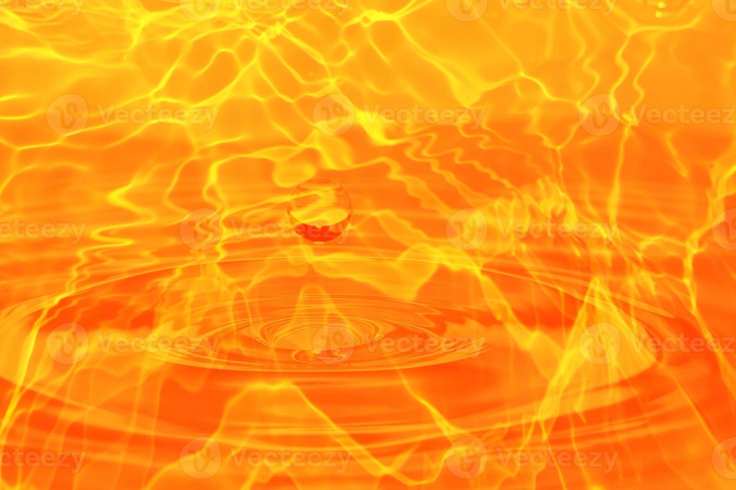 Defocus blurred transparent orange colored clear calm water surface texture with splashes and bubble. Trendy abstract nature background. Water wave in sunlight with copy space. Orange water drop color photo