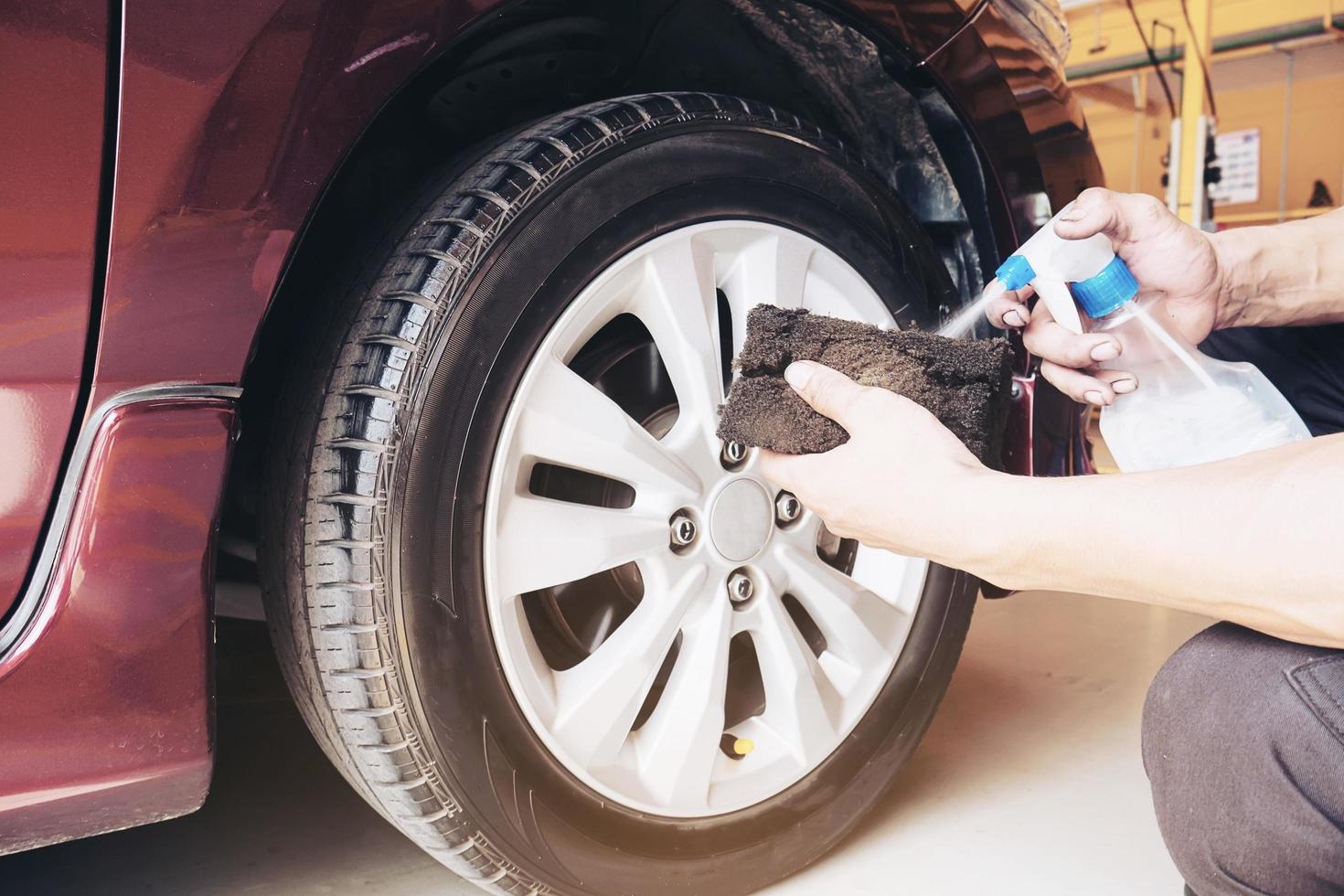 Service man is waxing car tire garage - car maintenance service concept photo