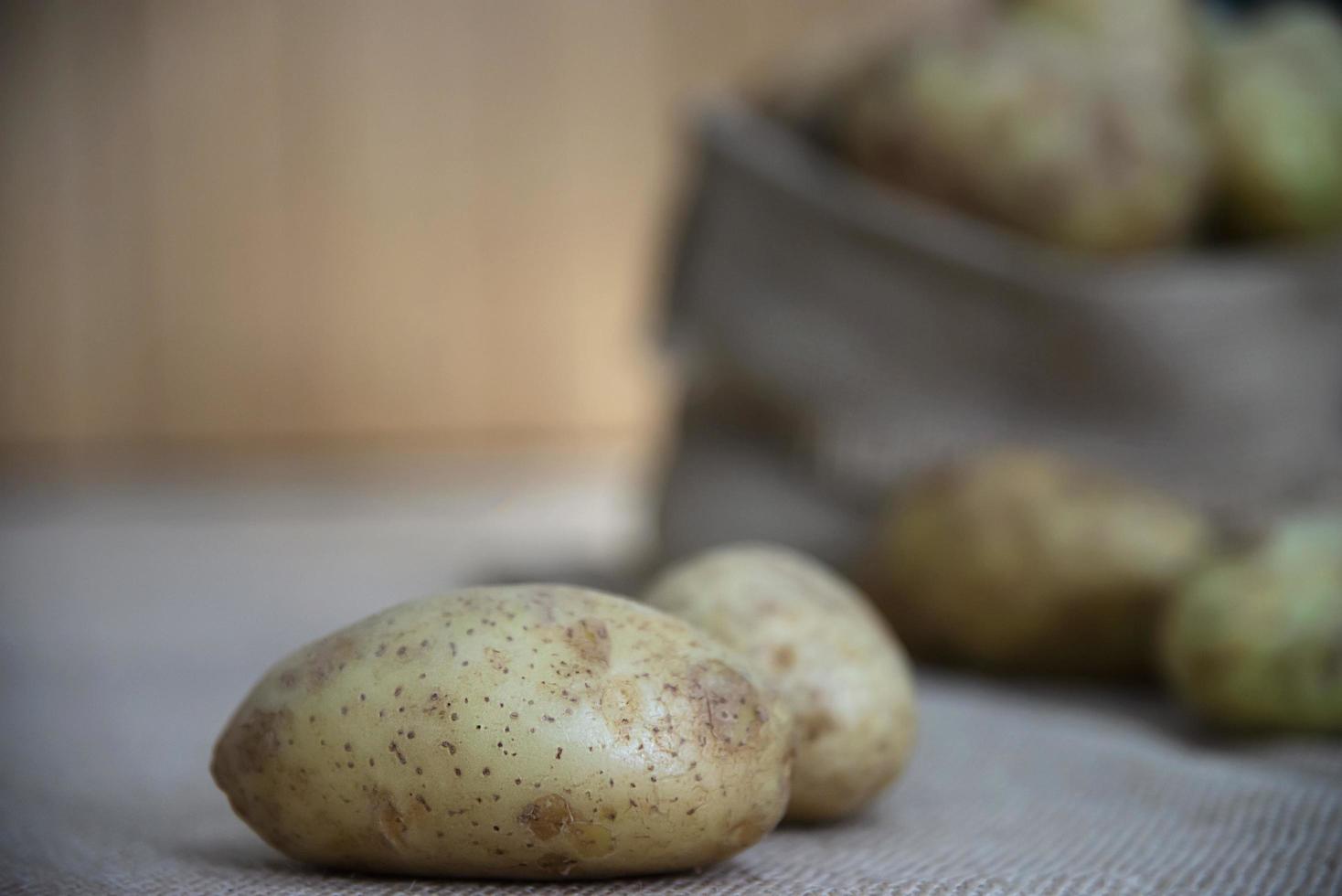 Fresh potato ready for cooking with potato sack background - potato cooking concept photo