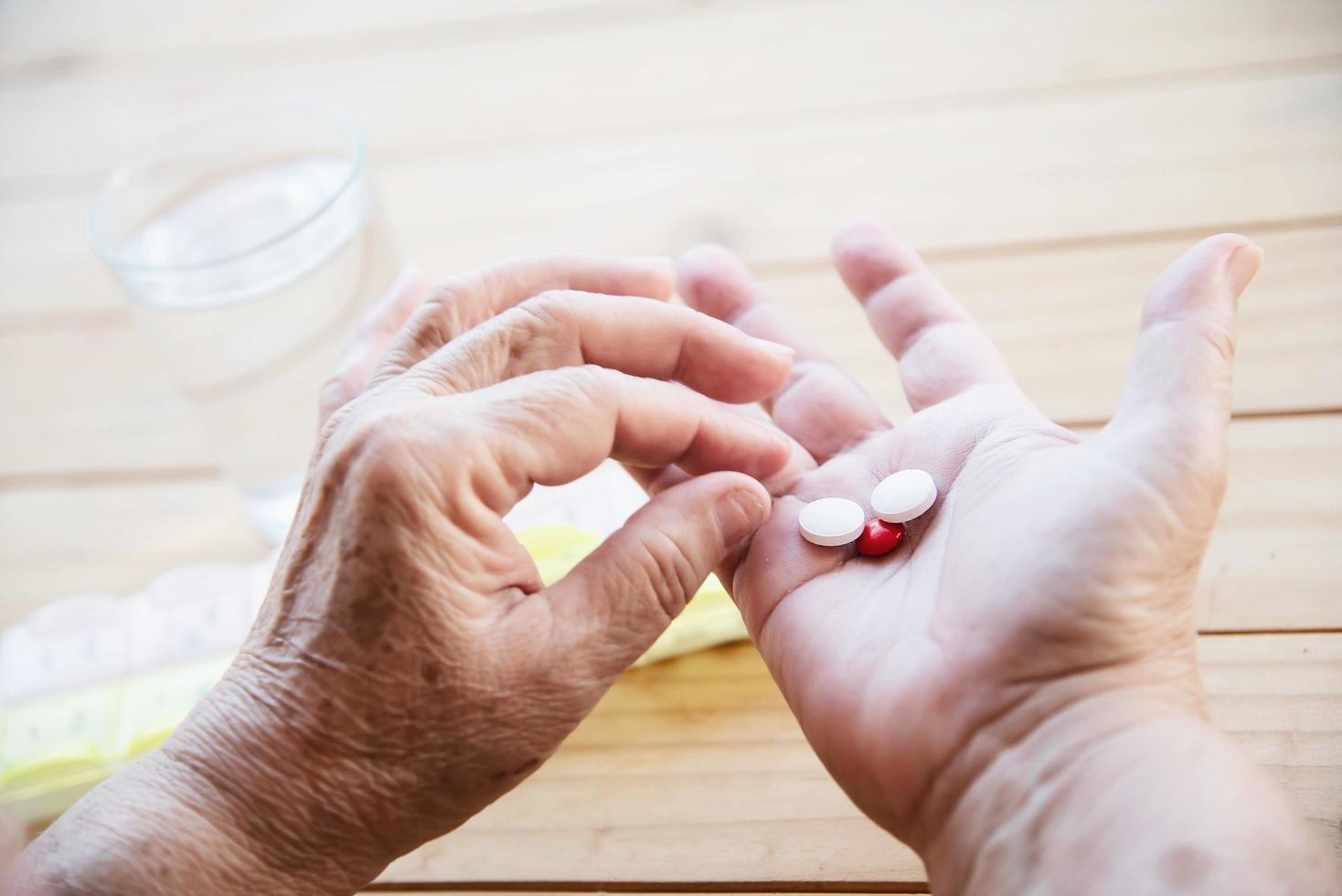 Old lady prepare to eat daily medicine pill - people healthcare with medicine pills concept photo