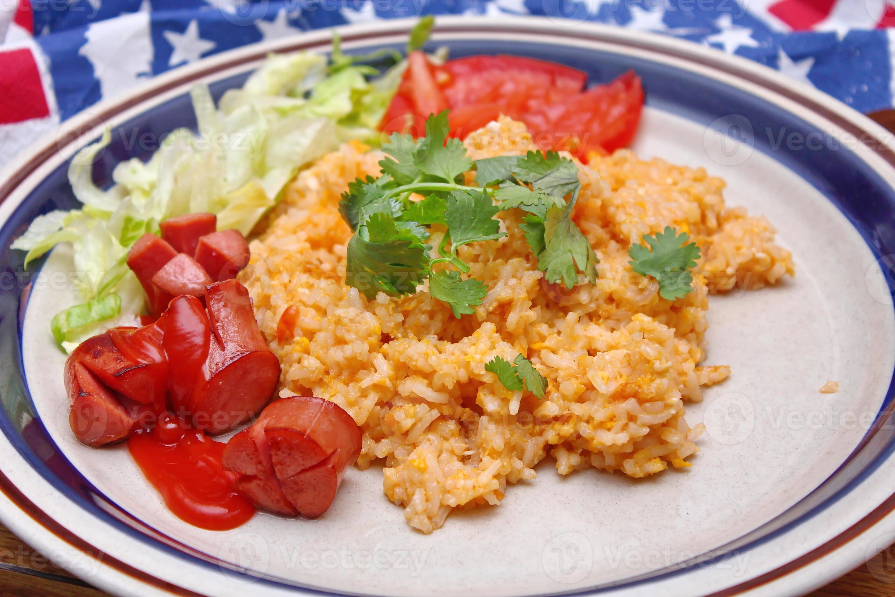 Fried rice with fried sausage served in a creamy dish with tomatoes and