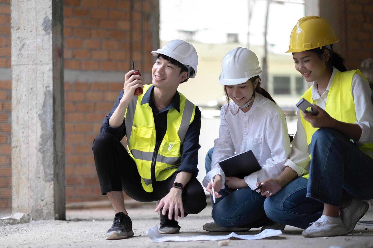 equipo profesional de construcción e ingenieros trabajando en el lugar de trabajo. el arquitecto negro profesional y el trabajador de la construcción que trabajan miran el plan de planos en el sitio. foto