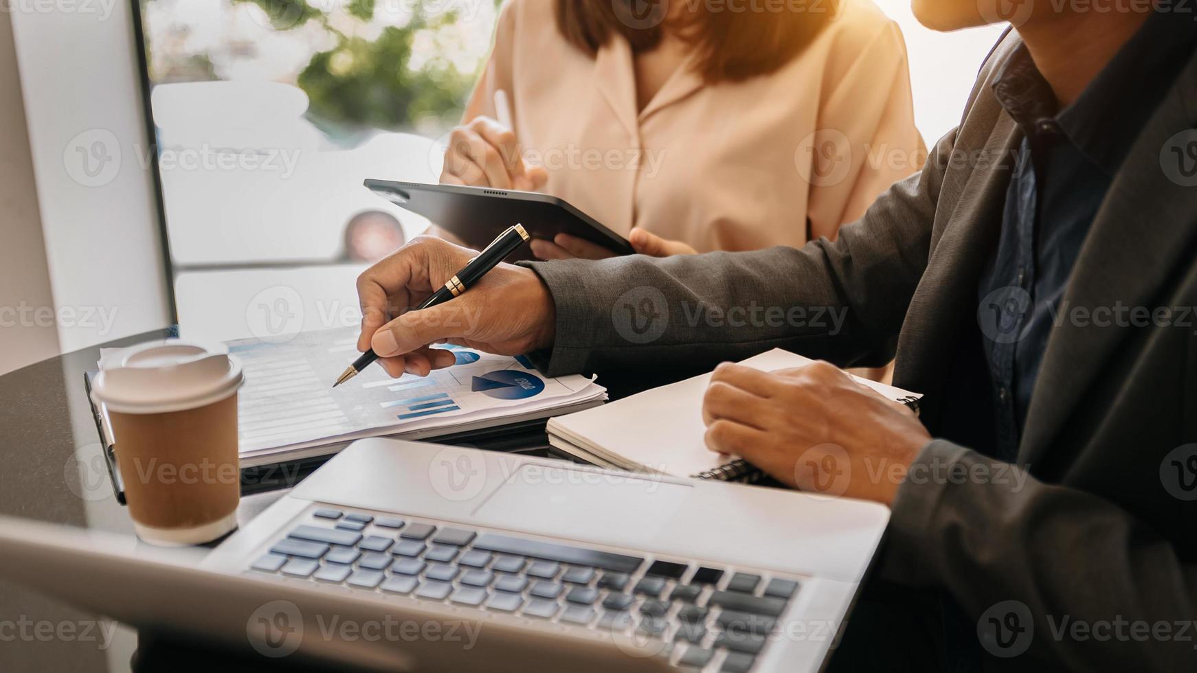 diversos empleados que trabajan en estadísticas o informes de proyectos financieros, escriben notas en papeles pegajosos coloridos, revisan documentos, estrategia comercial, trabajo en equipo foto