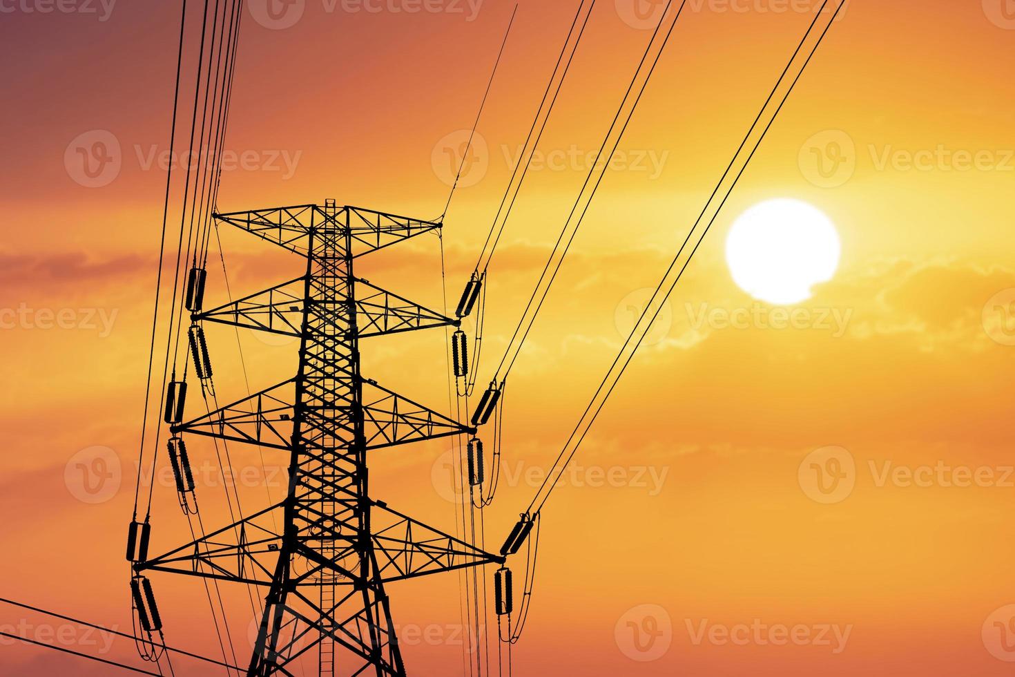 Silhouette of high voltage poles with electric wires. Silhouette of high voltage power line cables in an orange evening sunset. Steel structure of electric poles. electric power transmission concept photo