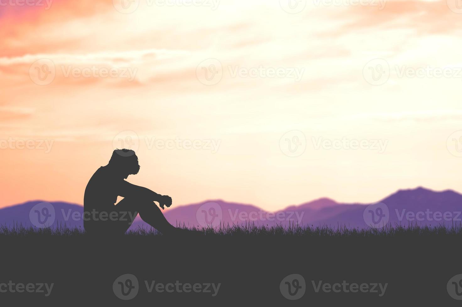 The concept of despair, discouragement, and loneliness. Silhouettes of people sitting with their heads down in sorrow in the meadows. photo