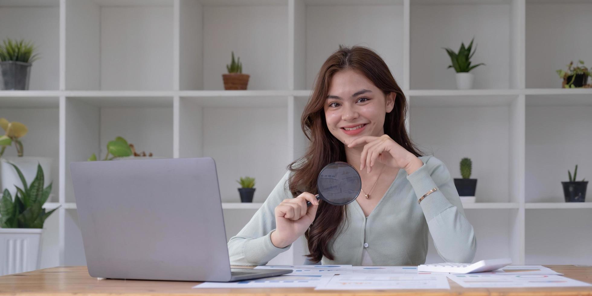 Business analyst using magnifying to review financial graphs, charts. Concept of Analyze return on investment and business analytics growth. photo