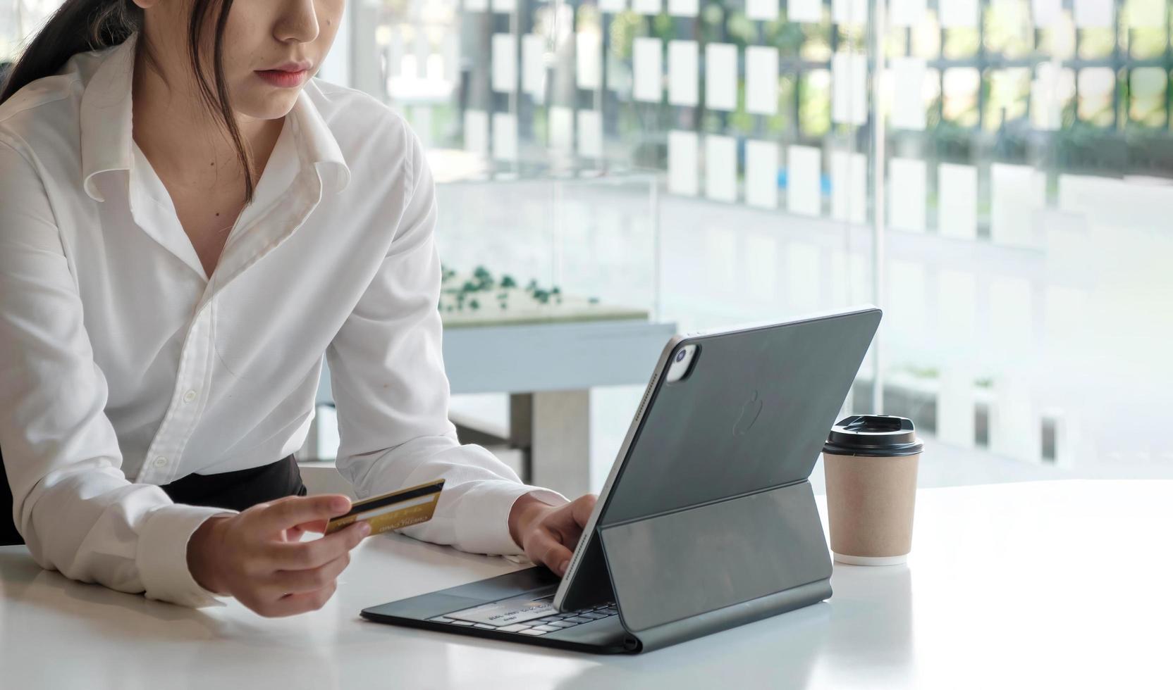 Young Asian businesswoman enjoy shopping online using credit card at a coffee shop. photo