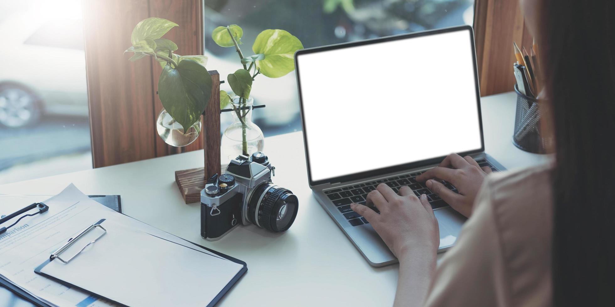 Young woman working with mockup laptop computer. photo