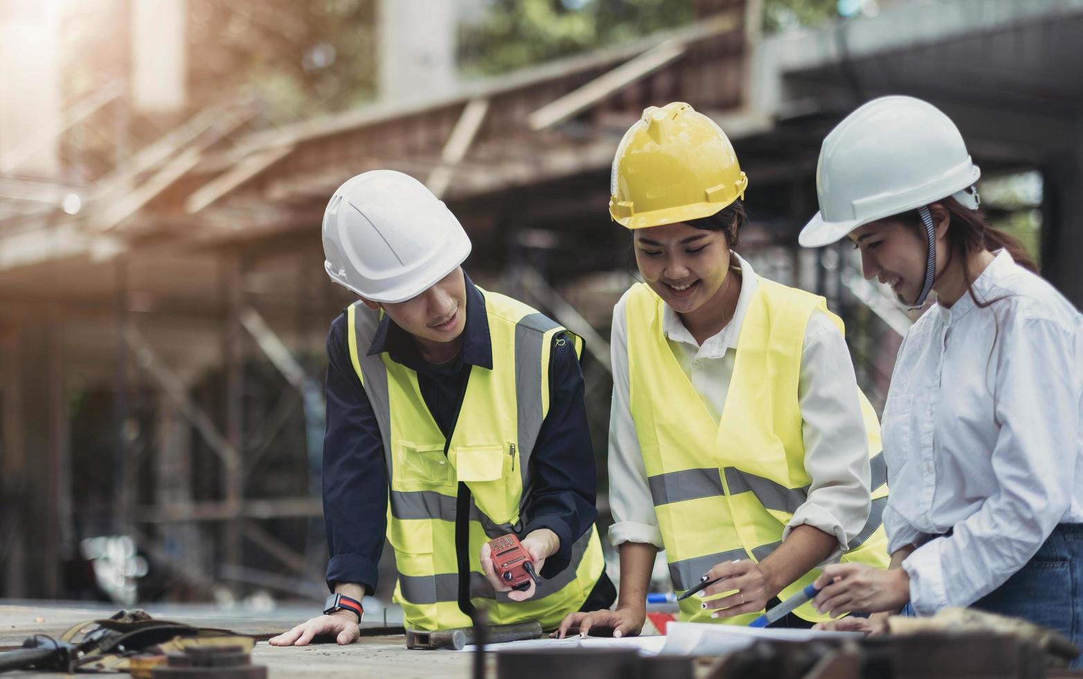 Three experts inspect commercial building construction sites, industrial buildings real estate projects with civil engineers, investors use laptops in background home, concrete formwork framing. photo