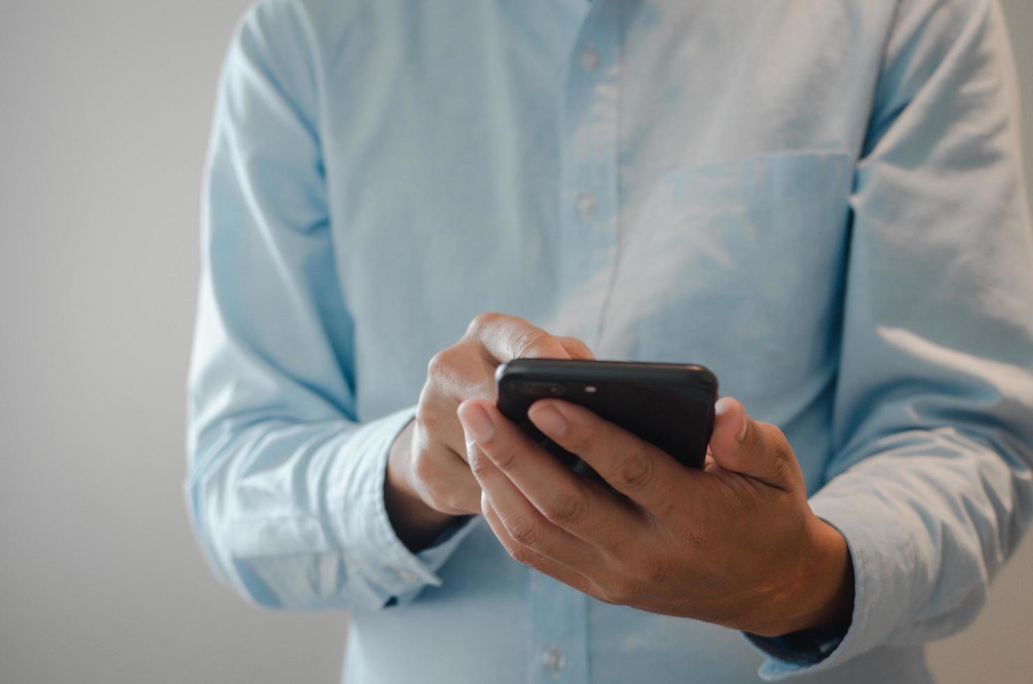 cierre la mano del hombre que sostiene el espacio de copia del teléfono inteligente móvil. persona que envía mensajes de texto concepto de tecnología de Internet. foto